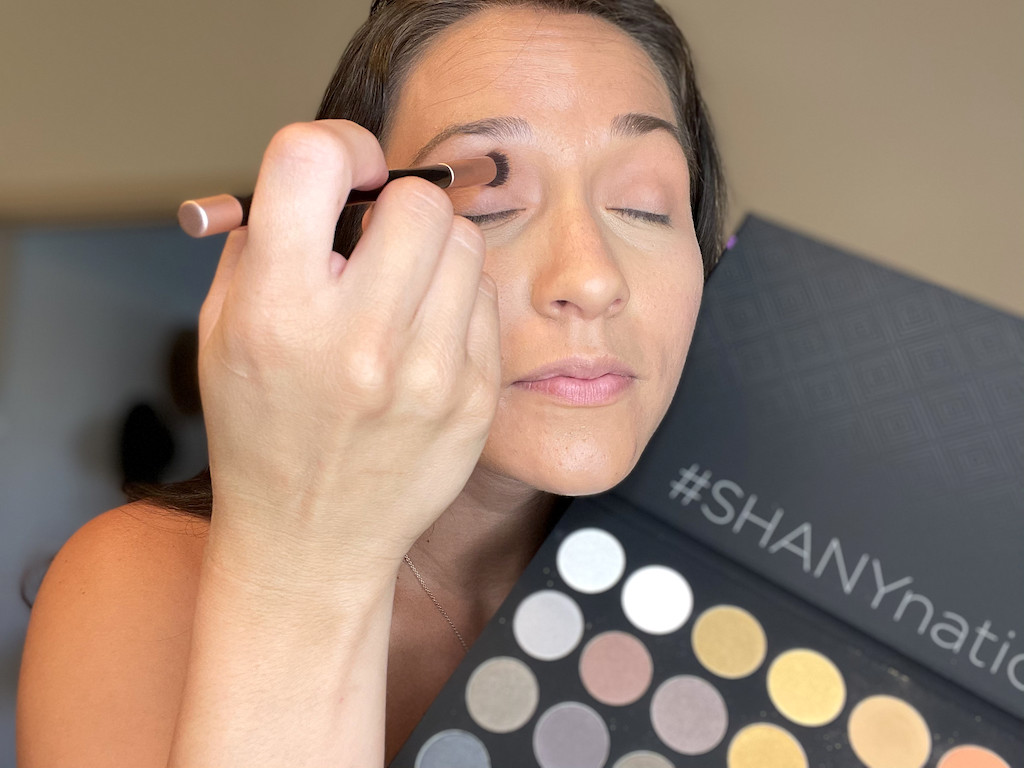 woman putting Shany eye shadow on 