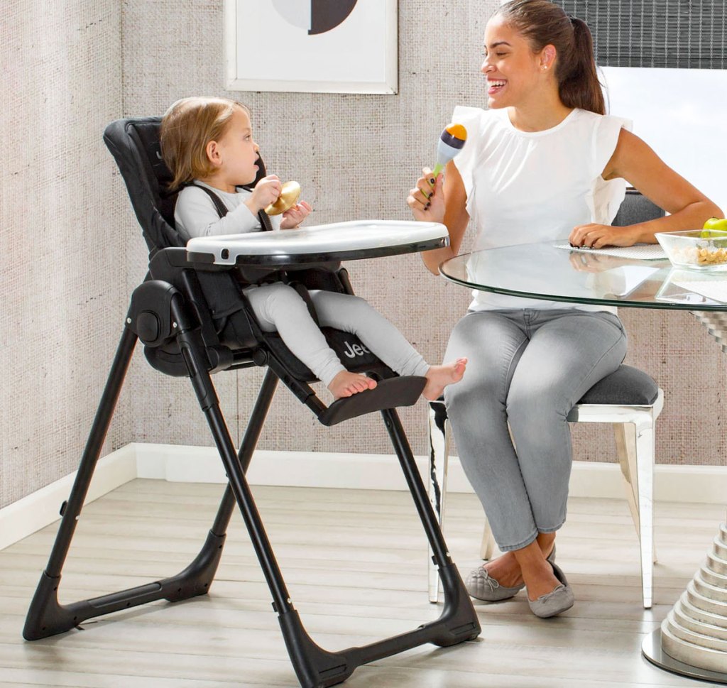 baby in high chair next to woman sitting at table