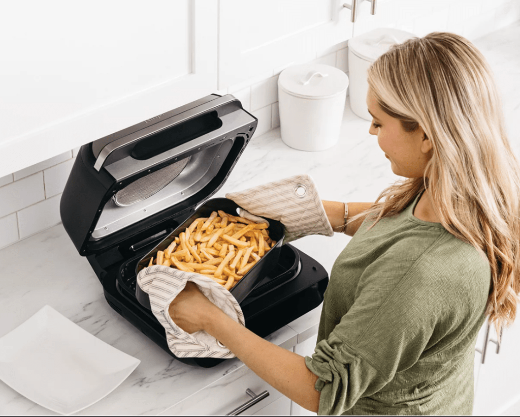 Ninja Foodi Grill with woman making fries