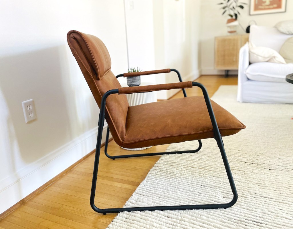 close up of brown leather mid century modern accent chair in living room