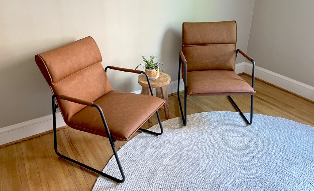 two modern leather chairs sitting on jute rug