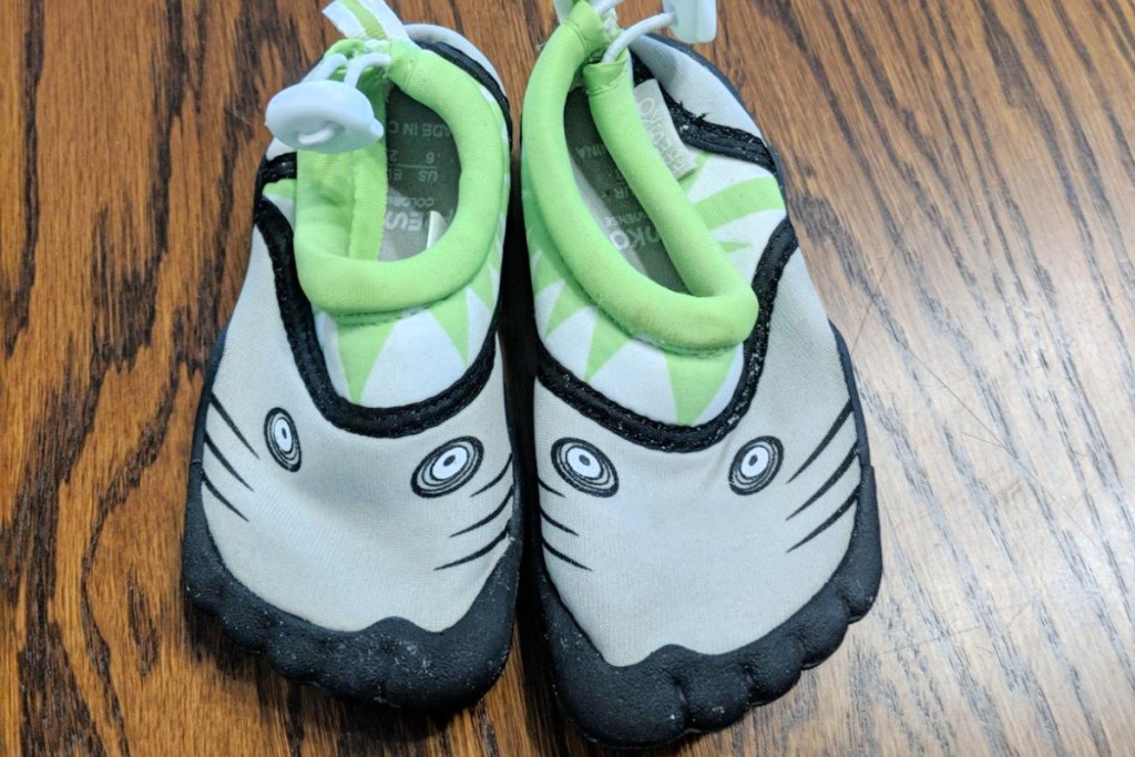 kids green and black fresko water shoes on wood table