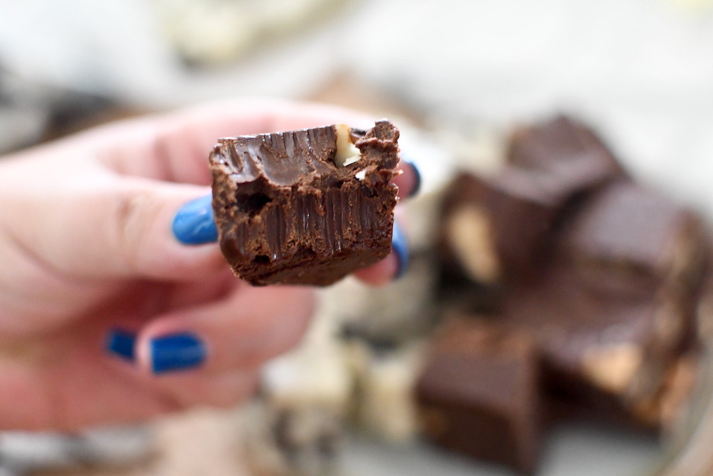 holding chocolate fudge with bite out of it 