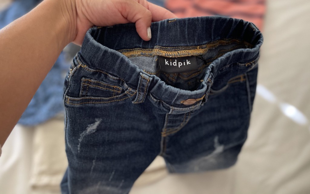 kidpik jeans in hand