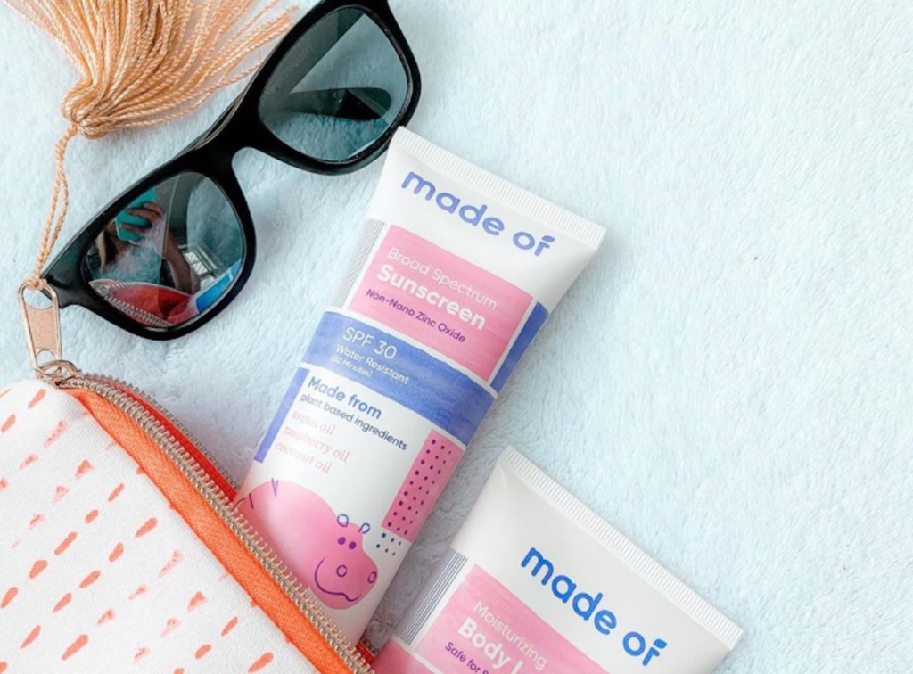 tube bottles of made of sunscreen lotion onlineing out of cosmetic bag with sunglasses