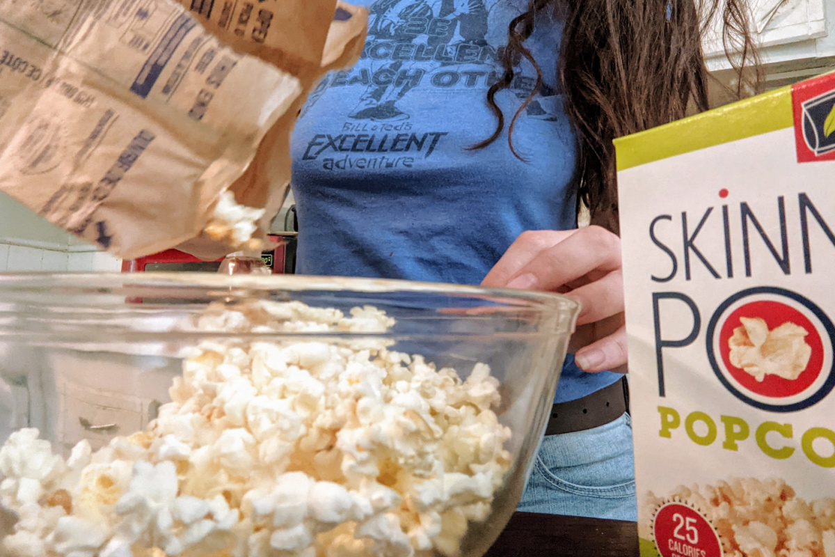 woman pouring popcorn into a bowl