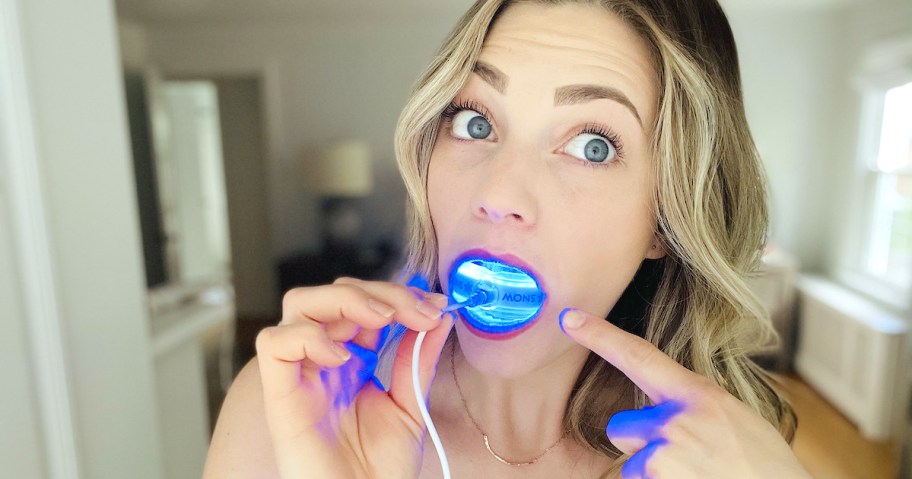 woman holding blue light in mouth