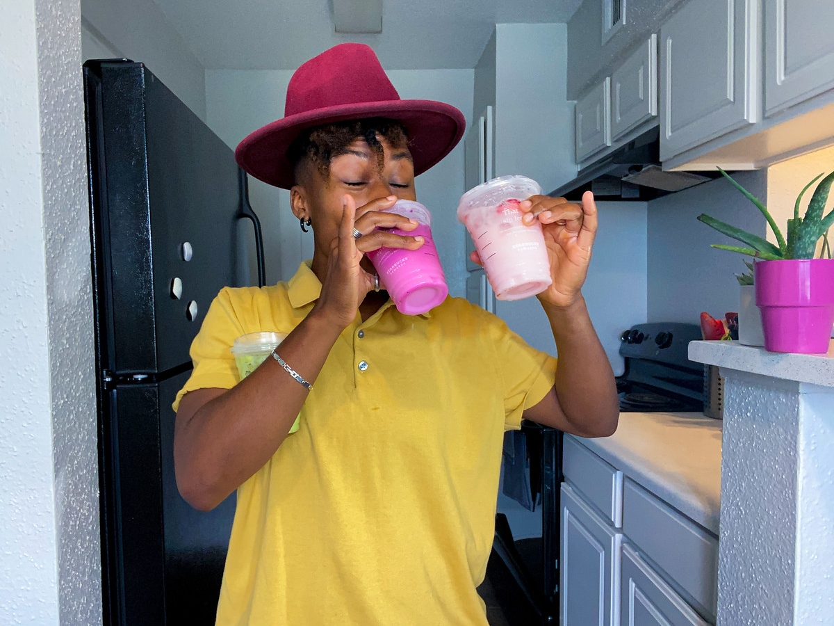 woman with three iced Starbucks drinks