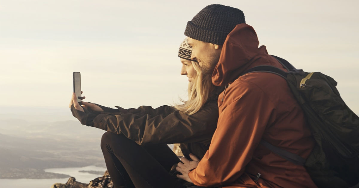 Man and woman taking selfie on mountain