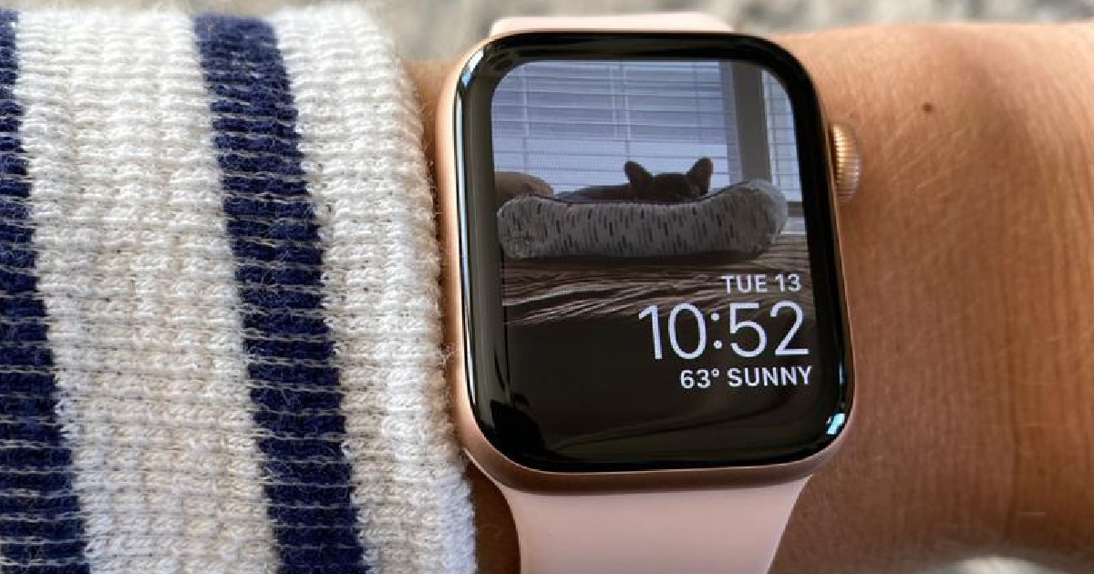 close up of a wrist with an apple watch reflecting a cat in a cat bed