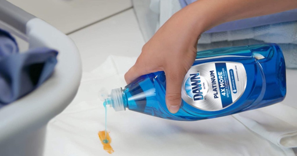 person pouring dish soap on a stain