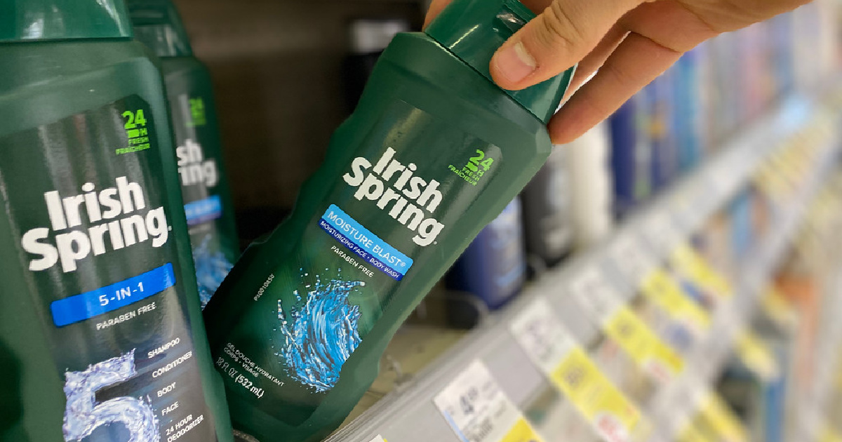 man's hand pulling bottle of body wash off store shelf