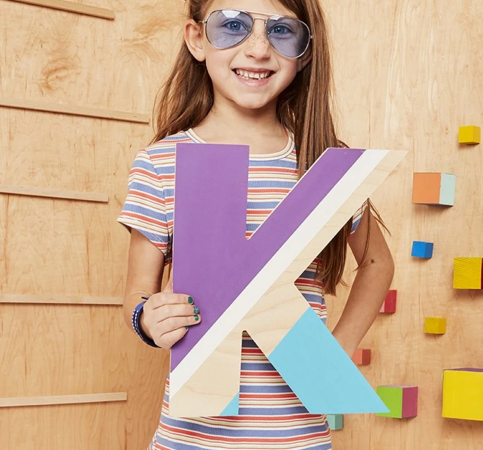 girl holding a large letter K