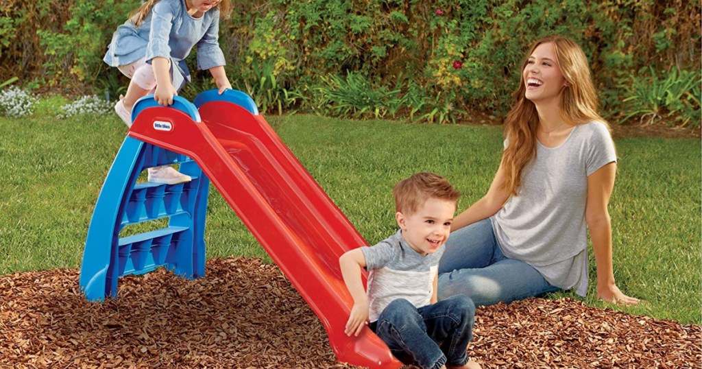 family playing on a slide outside