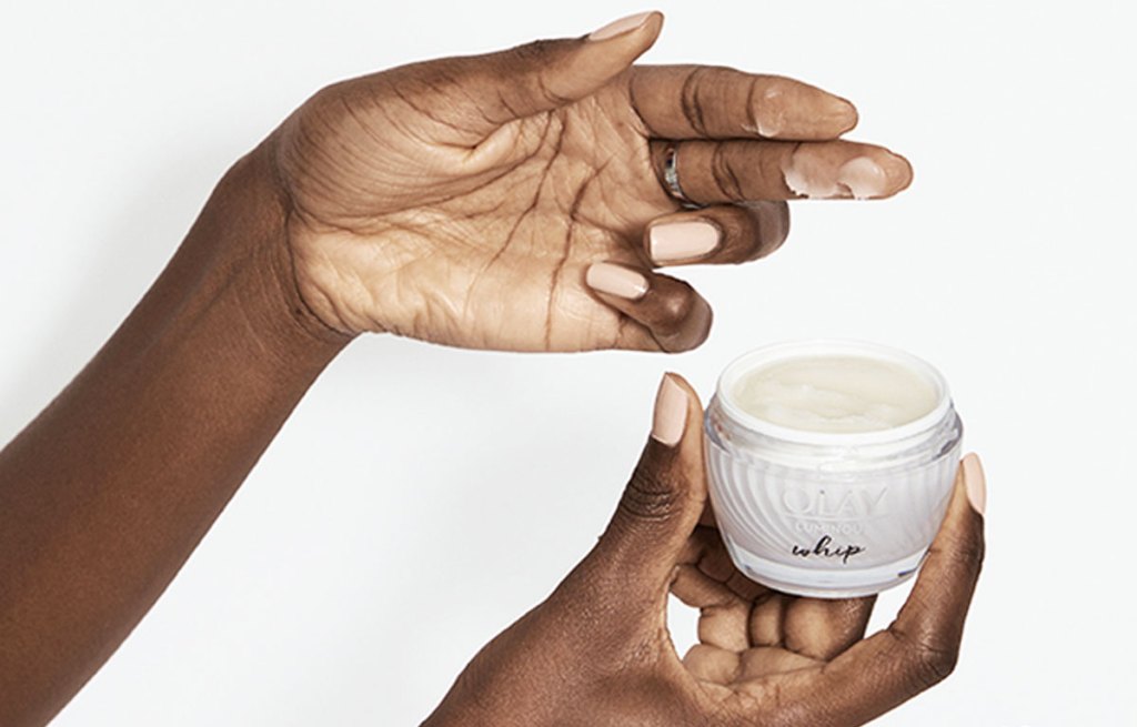 woman holding up jar of olay whip moisturizer