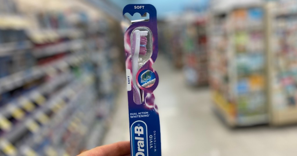 hand holding toothbrush in aisle 