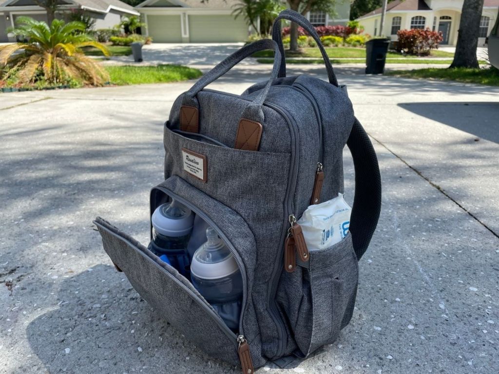 gray diaper bag backpack slightly opened to reveal baby bottles