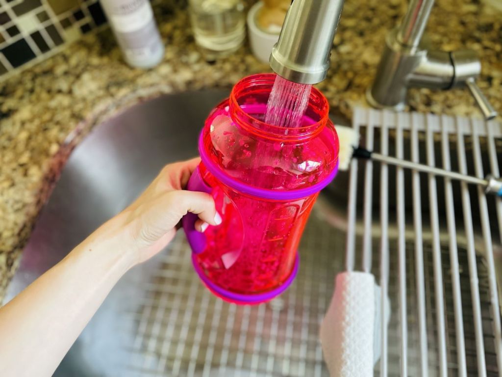 hand filling up a water bottle