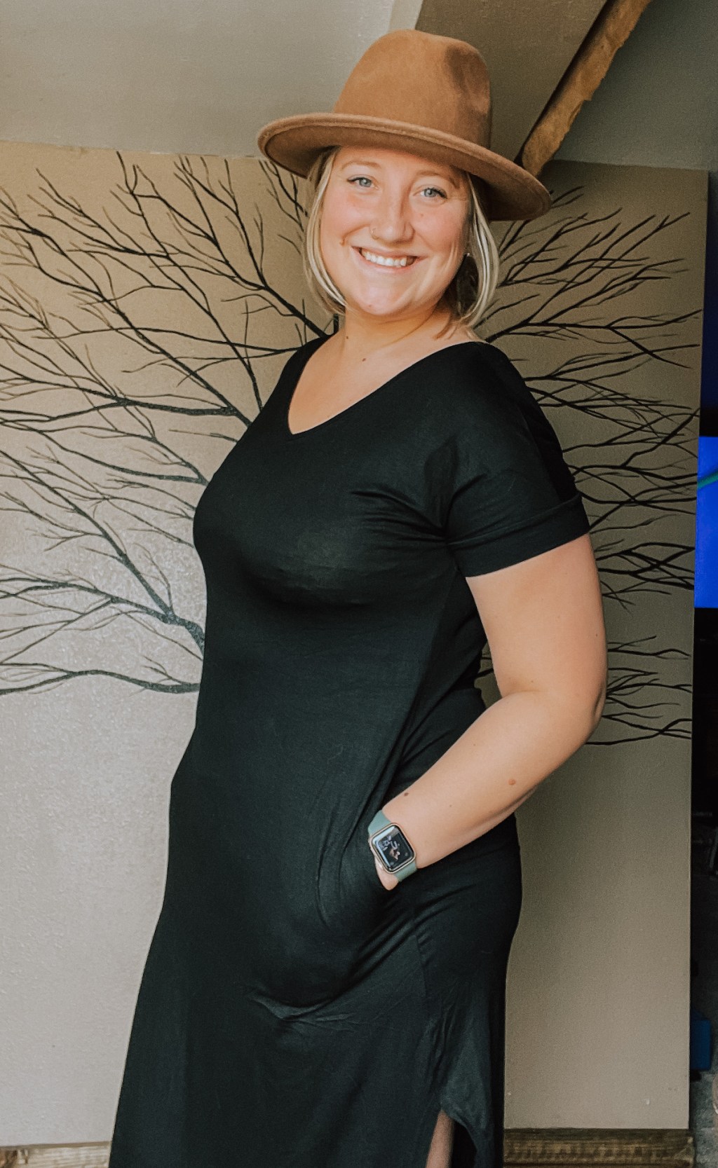 woman smiling wearing black maxi dress and brown wide brim hat