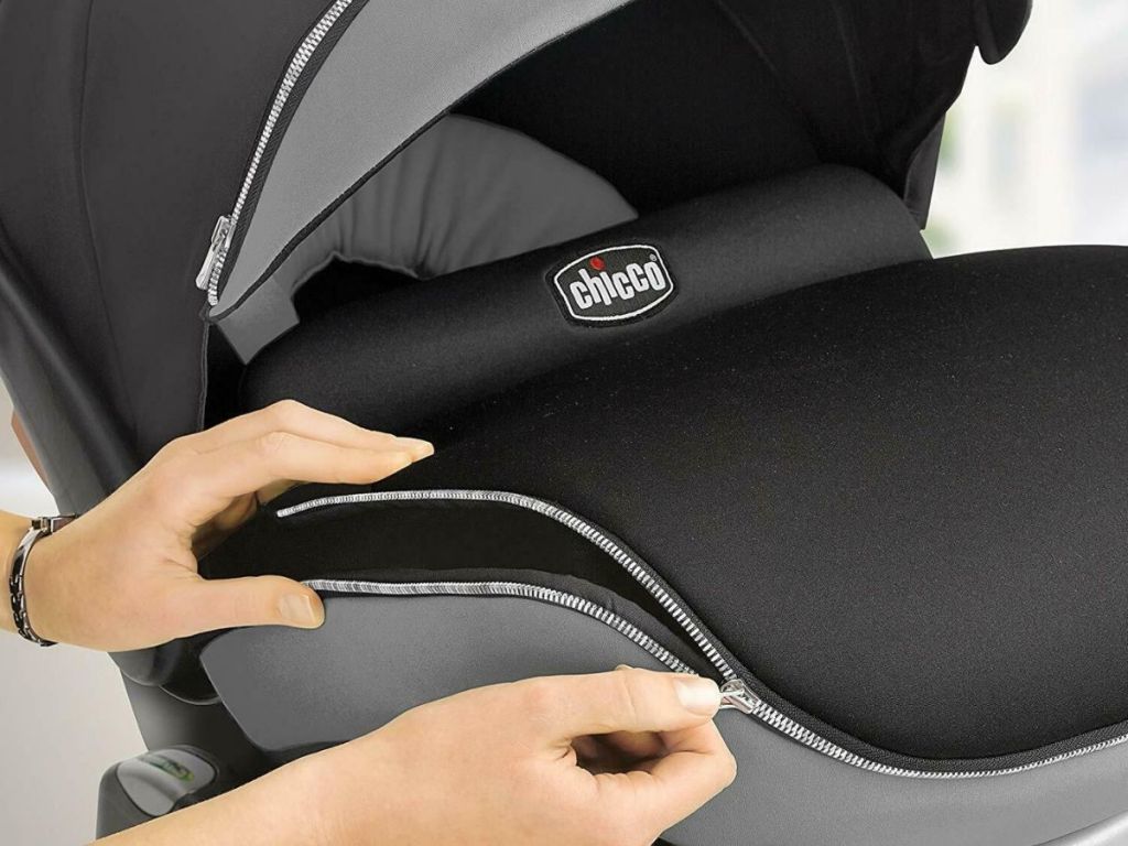 woman zipping up Chicco car seat