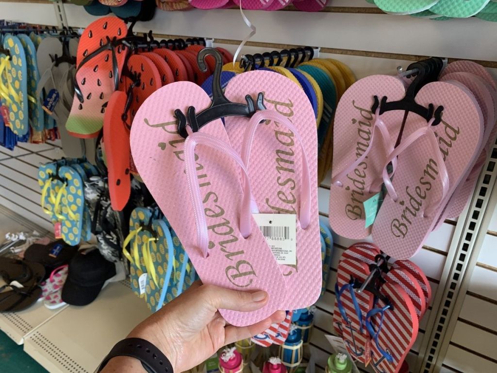 hand holding pink Bridesmaid flip flops