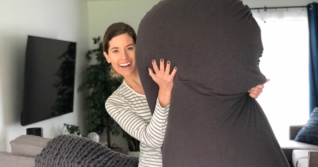 woman holding mood pod bean bag chair smiling