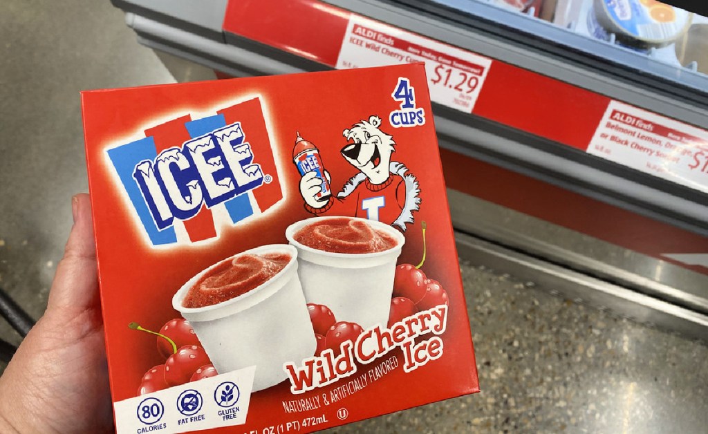 hand holding a box of icee wild cherry cups above an aldi refrigerated case