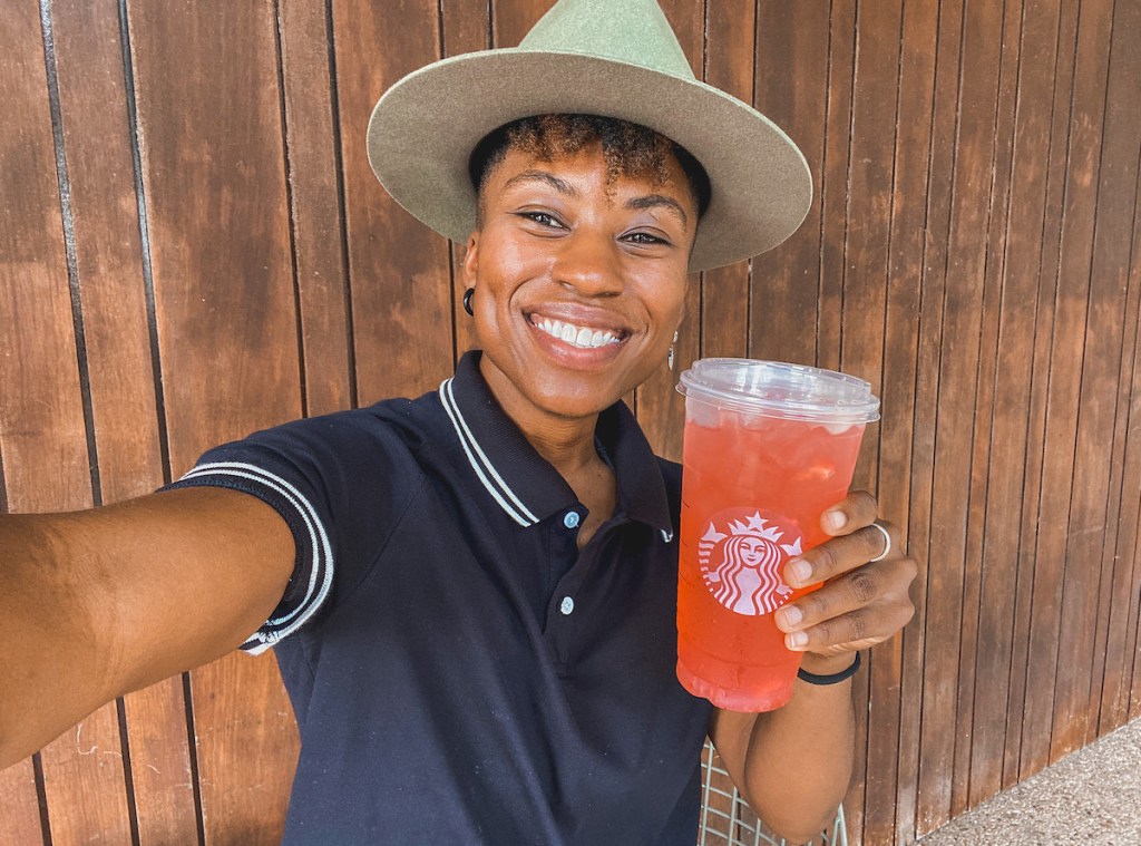 woman holding starbucks gummy bear secret menu drink smiling