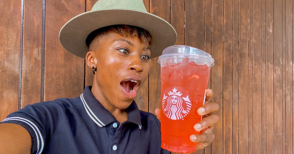 woman with mouth open staring at pink gummy bear drink in starbucks cup