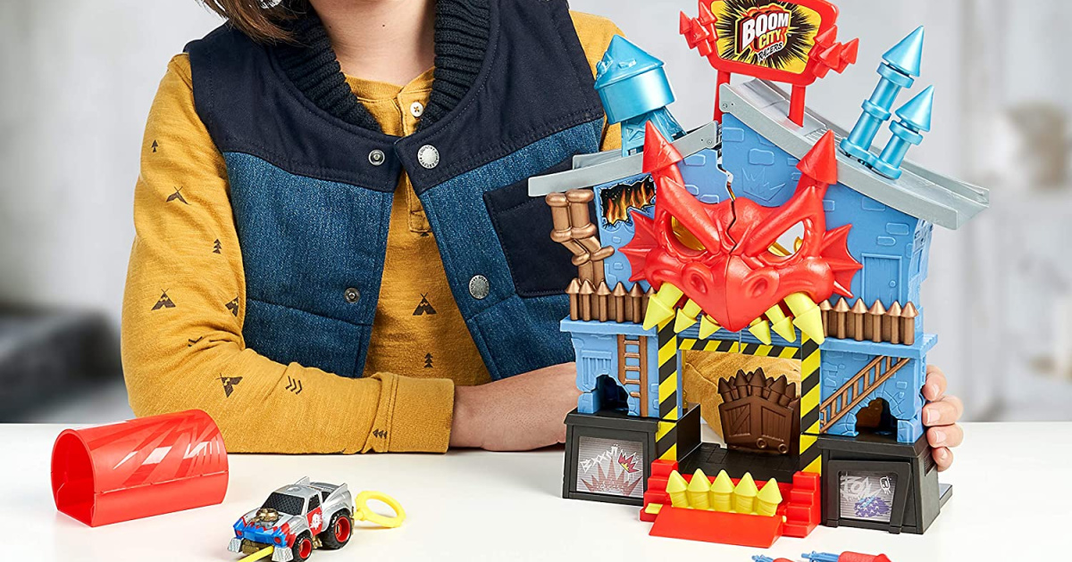 child at a table behind a firehouse factory playset