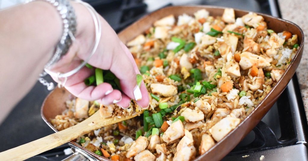 putting green onions on chicken fried rice 