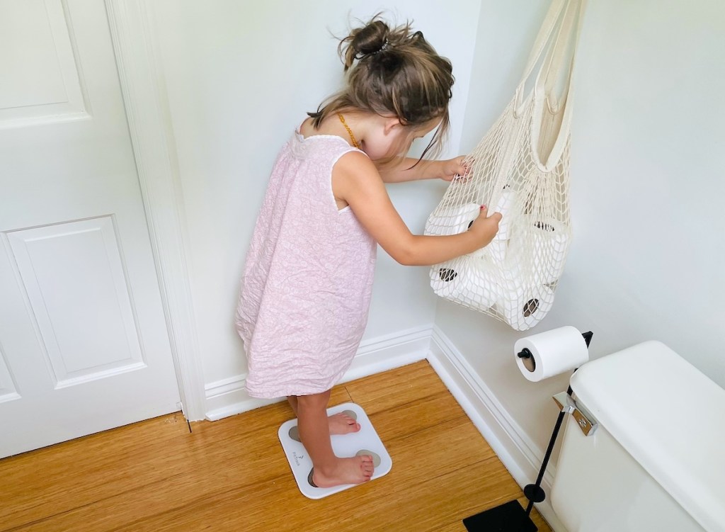 girl standing on smart scale in bathroom