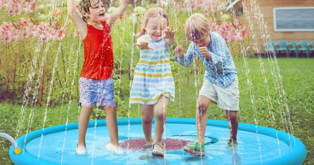 three kids playing in a sprinkler