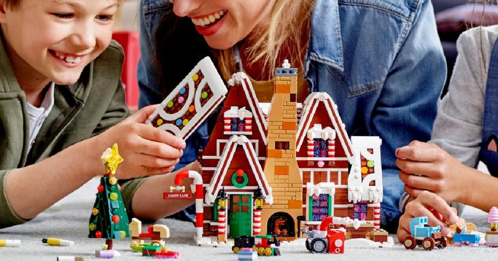 family putting together a LEGO gingerbread house set