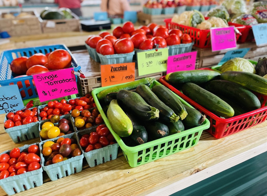 tomatos and zucchini in baskets at farmers market