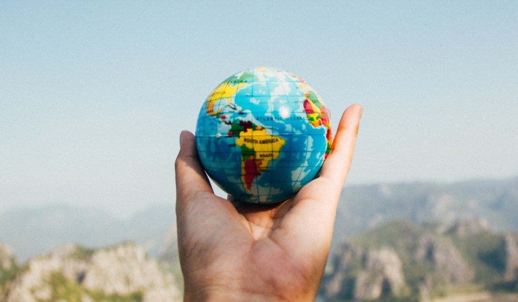 person holding globe in hand