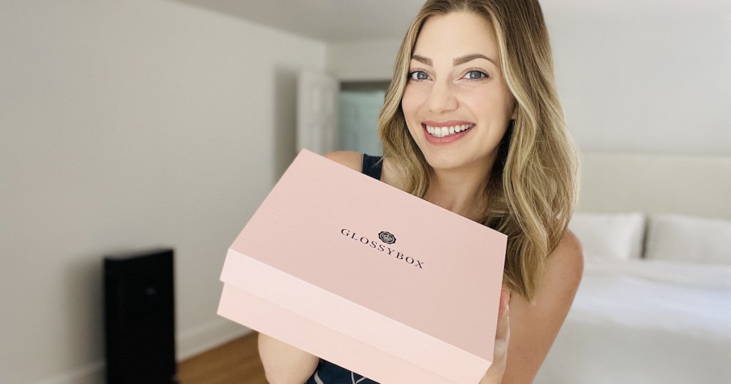 woman holding up pink glossybox box