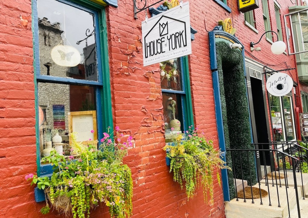 storefronts on city street with flowers