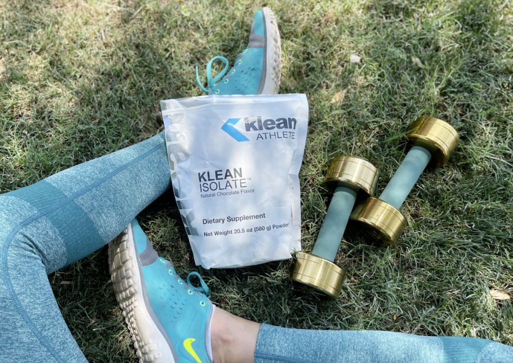 klean athlete protein powder in grass outside