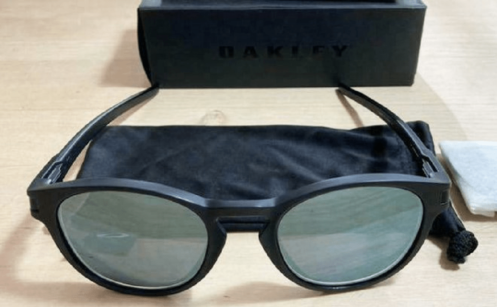 pair of sunglases with black frames sitting on table next to case