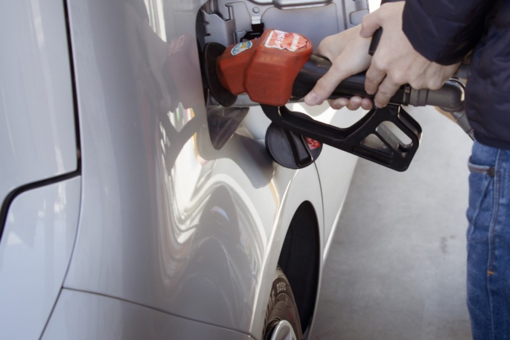 hand pumping gas into car