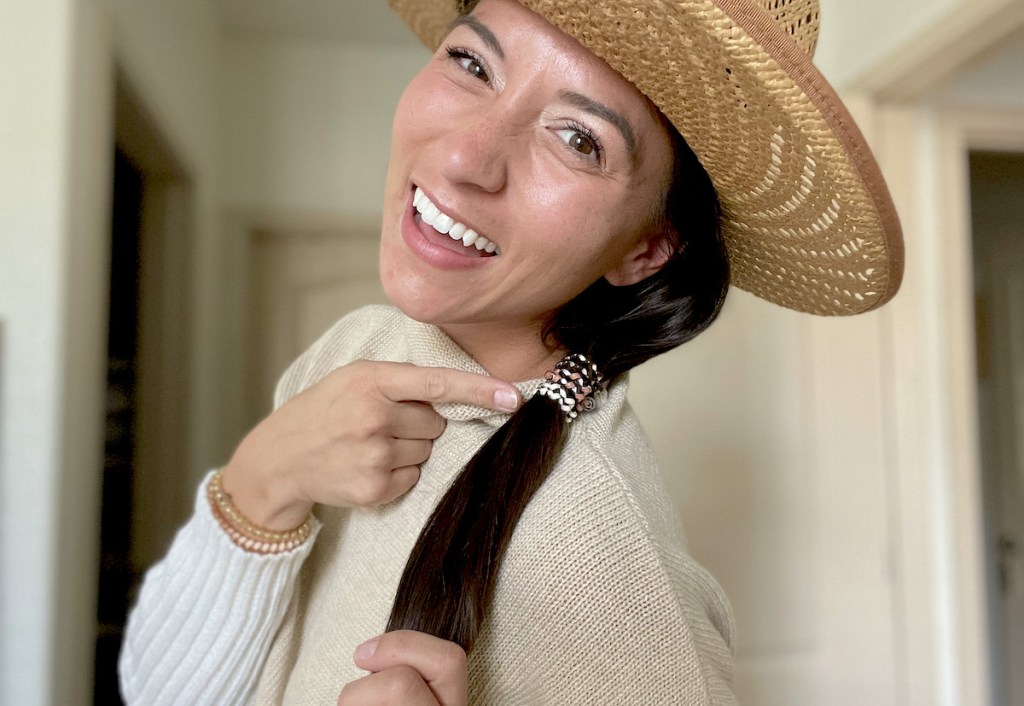 woman pointing to coiled hair ties in ponytail