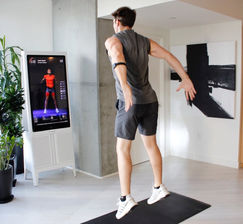 man jumping in front of workout mirror