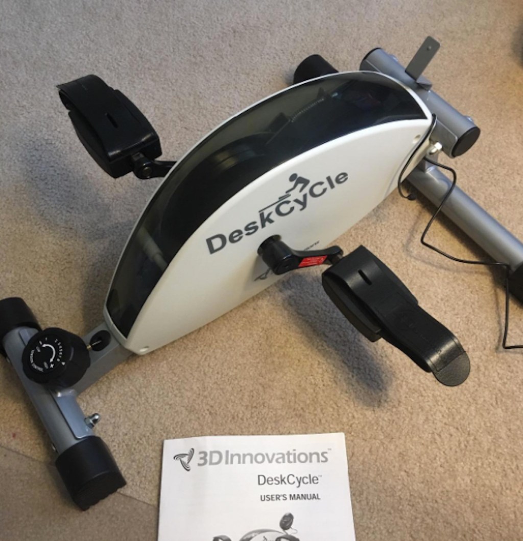 deskcycle under desk exercise bike sitting on floor with user manual