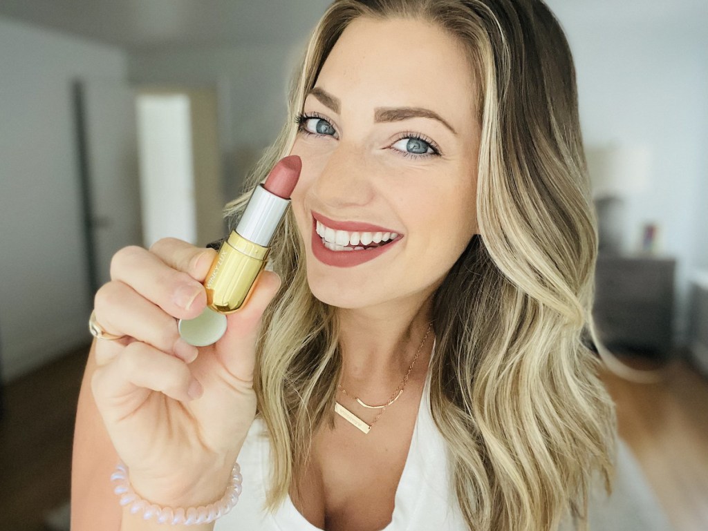 woman holding up winky lux matte lipstick