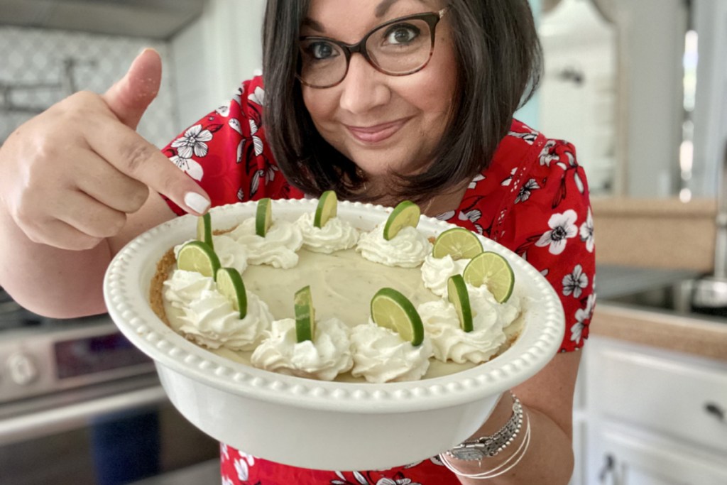 woman holding a key lime pie