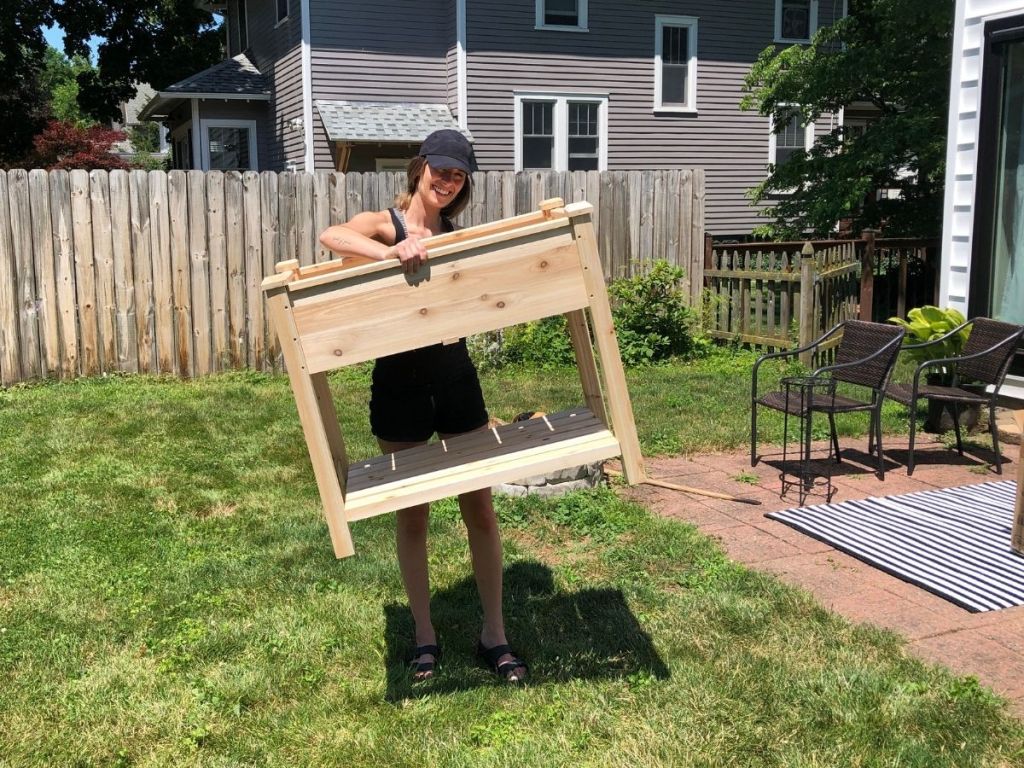 woman holding up wooden garden bed