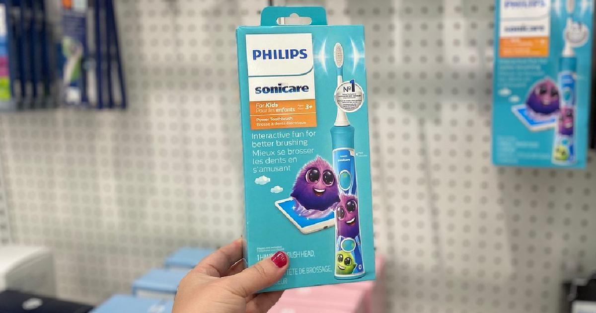 hand holding up a sonicare kids electric toothbrush in a store