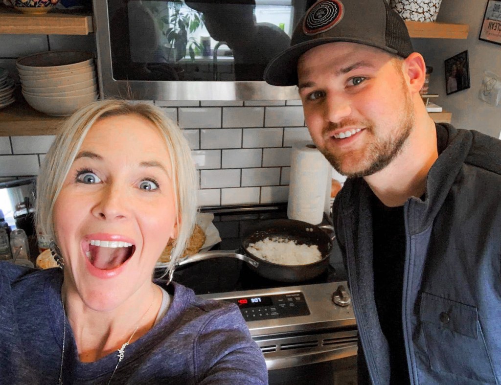 man and woman standing in kitchen cooking