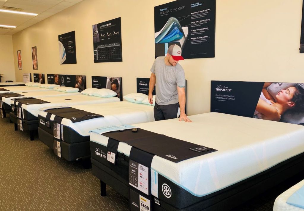 man standing next to a mattress